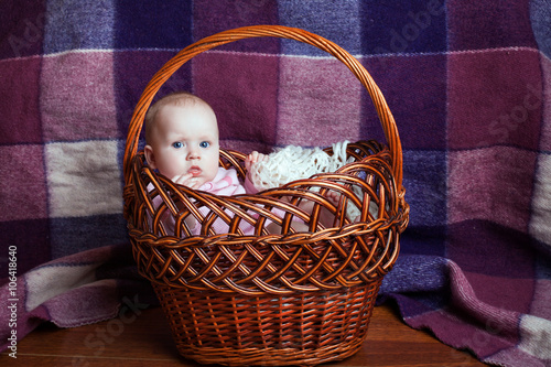 Little beautiful girl sitting in a basket
