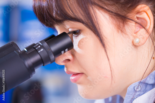 woman technician looking in microscope