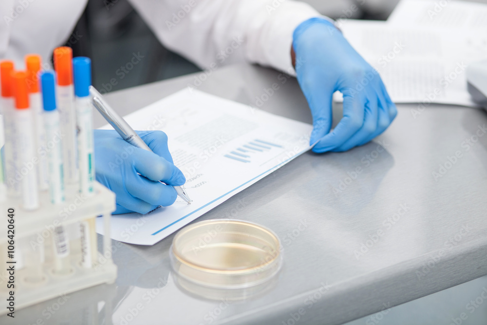 Cheerful young scientist is working with papers Cheerful young scientist is working with papers