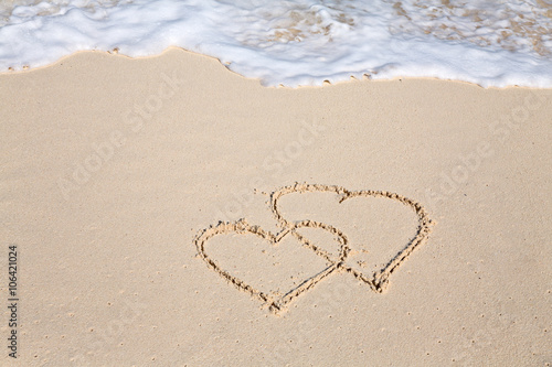 Two hearts drawn on the beach sand