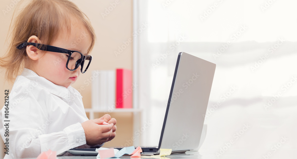 Smart toddler girl wearing big glasses using her laptop Smart toddler girl wearing big glasses using her laptop