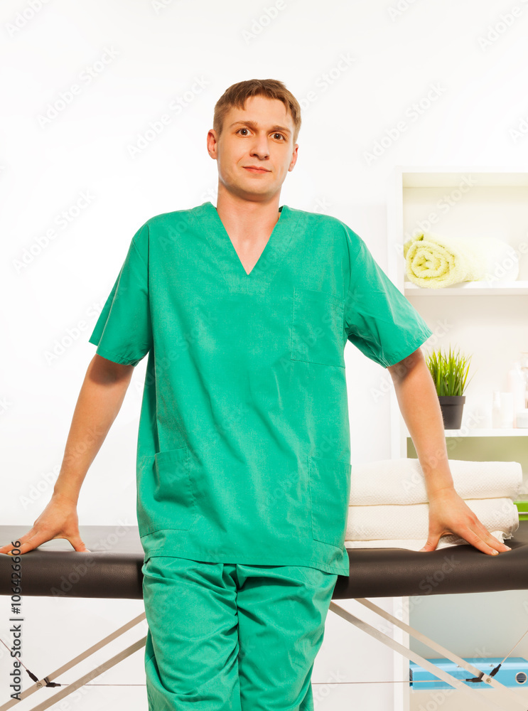 Fototapeta premium Young masseur in a uniform at the massage cabinet