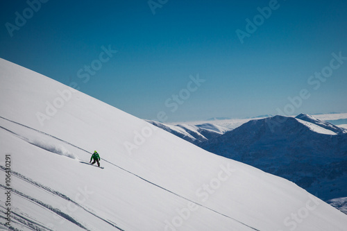 Male skier skiing in fresh snow on ski slope on a sunny winter day at the ski resort in Georgia