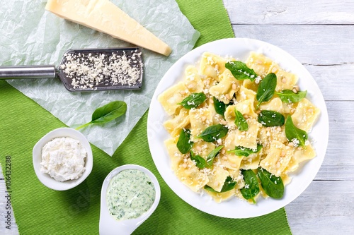 Papier peint italian ravioli with creamy spinach sauce, top view