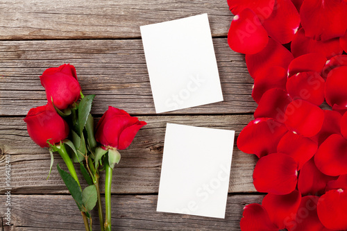 Red roses, photo frames and petals