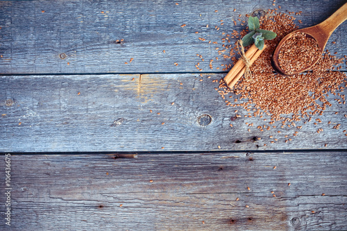 Wooden spoon with flax seeds, mint and cinnamon on a wooden old