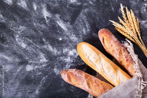 bread with wheat ears on dark board photo