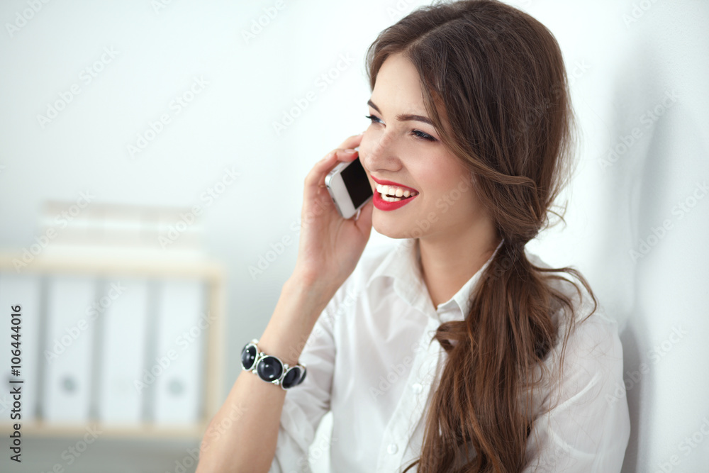 Smiling businesswoman talking on the phone at the office Smiling businesswoman talking on the phone at the office