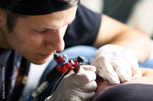 Tattooist makes tattoo, clo...