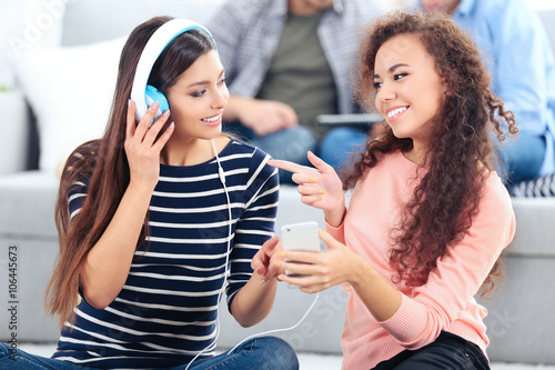 Two teenager girls listenin...
