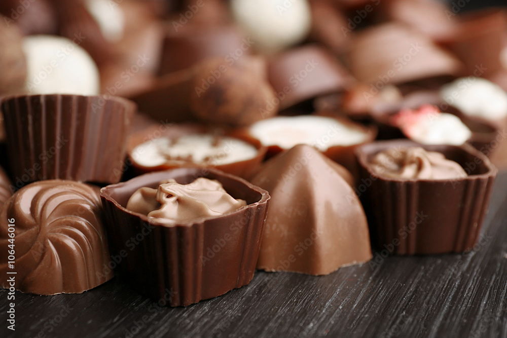 Delicious chocolate candies on wooden background, close up Delicious chocolate candies on wooden background, close up