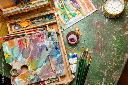 Colorful workplace of the artist with brushes and oil paints photo