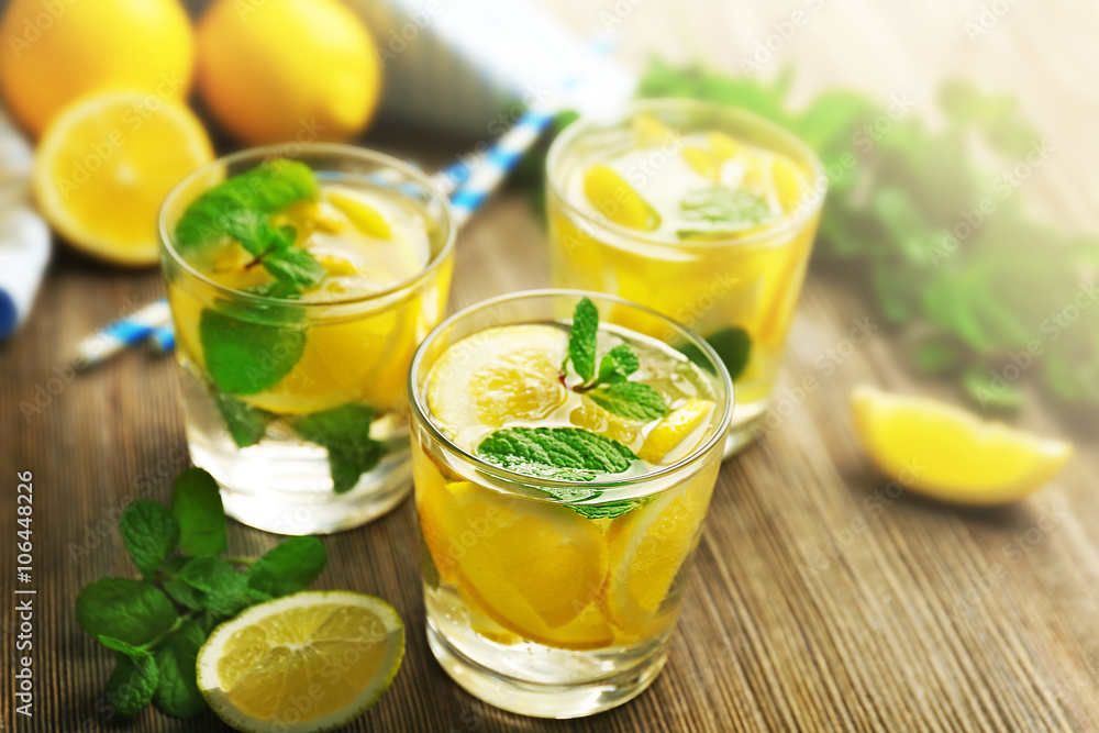 Composition of lemonades, lemons and mint on wooden table background, closeup Composition of lemonades, lemons and mint on wooden table background, closeup