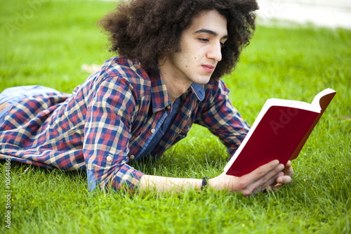 Young man read book in grass photo