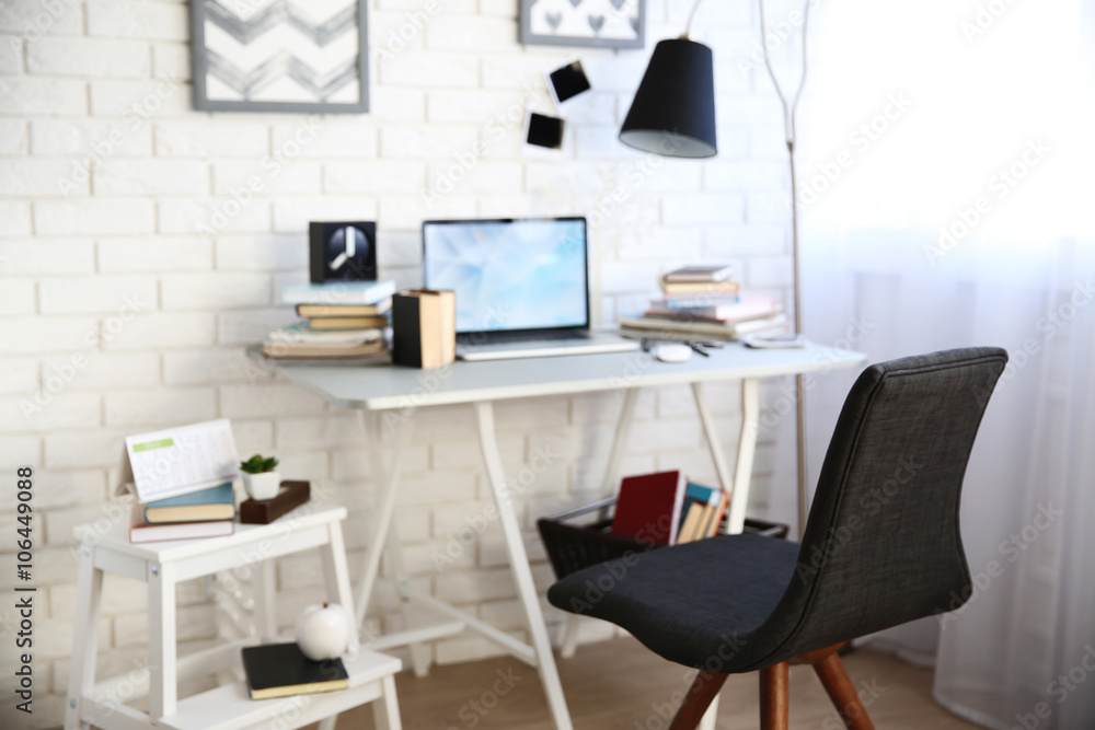 Workplace with laptop, table, lamp and chair in light room Workplace with laptop, table, lamp and chair in light room
