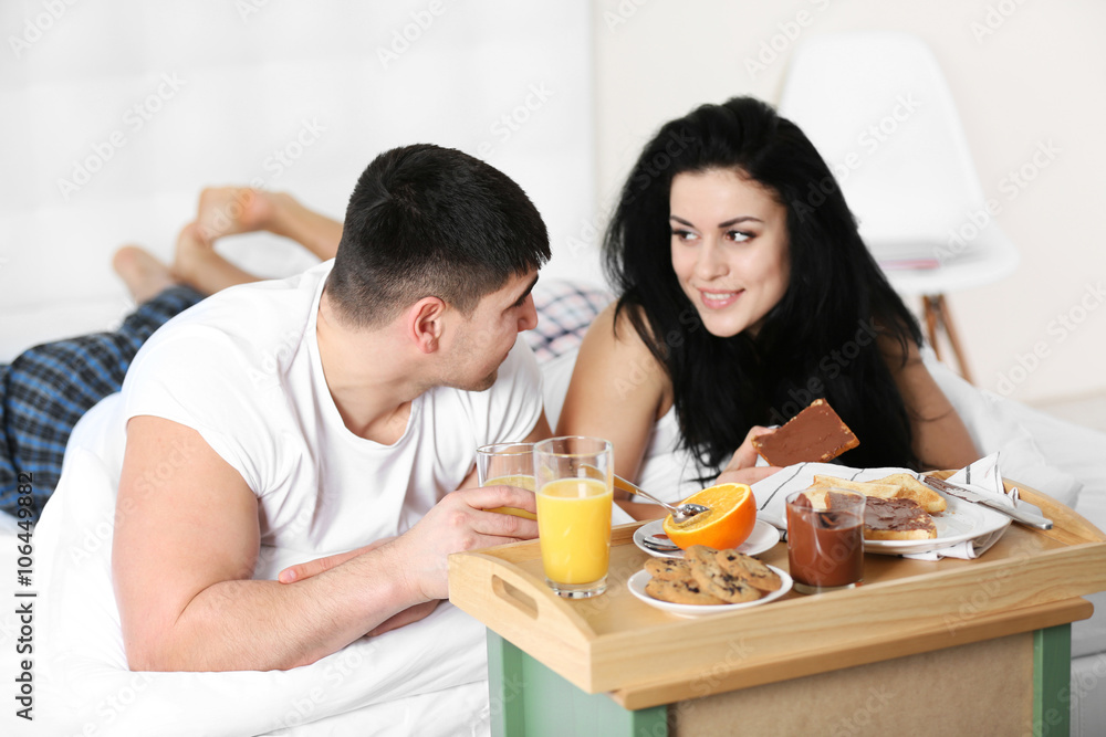 Lovely couple having breakfast in bed
