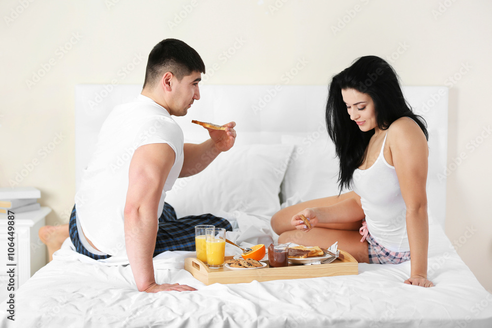 Lovely couple having breakfast in bed