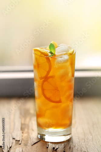 Glass of iced tea with lemon on a windowsill