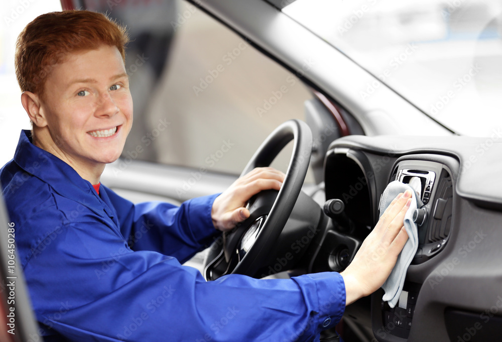 Young man polishing vehicle interior
