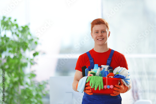 Young janitor holding clean...