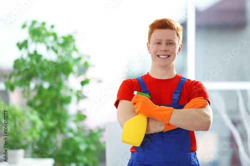 Young janitor holding liqui...