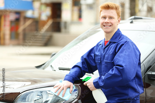 Young man cleaning car lights