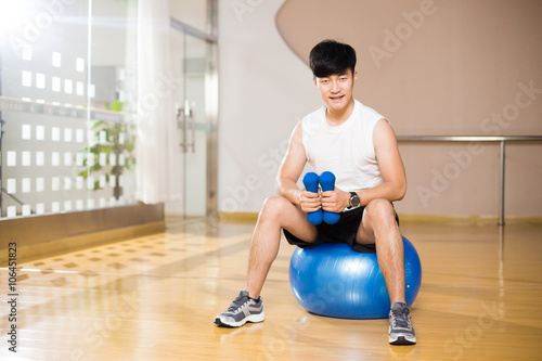 young handsome asian man works out in modern gym