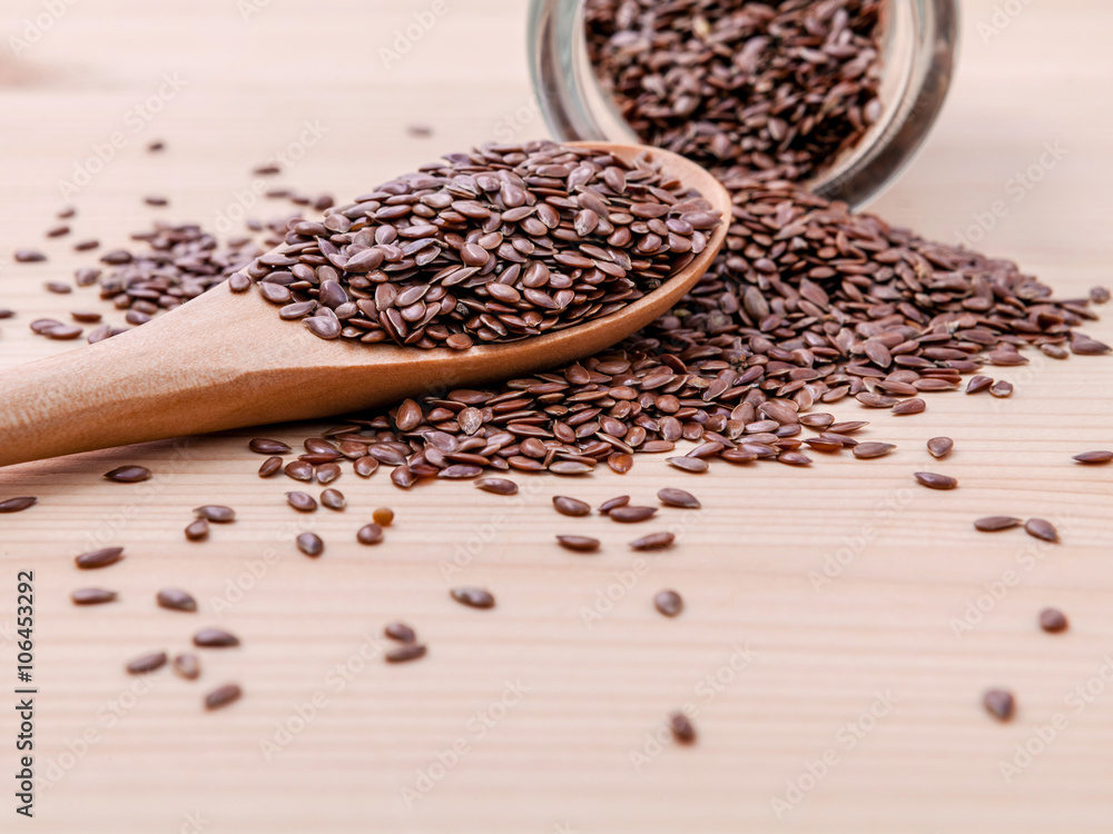 Nutritious flax seeds in glass bowl and wooden spoon for diet fo Nutritious flax seeds in glass bowl and wooden spoon for diet fo