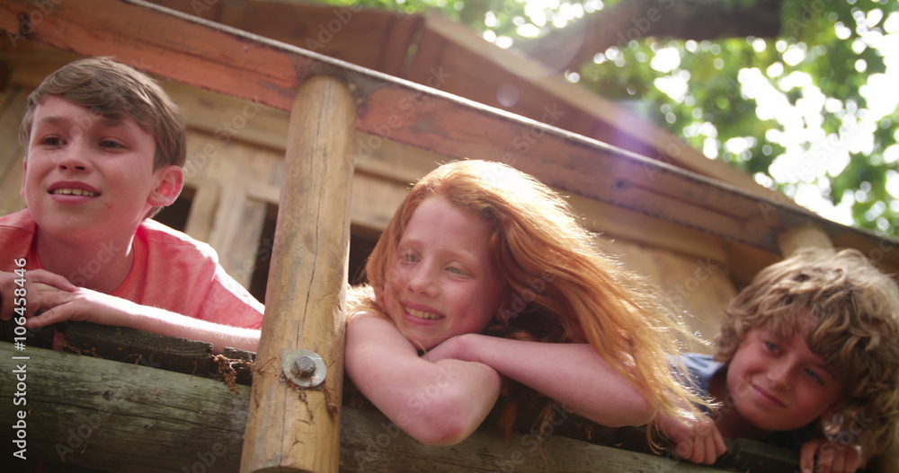 Children in a treehouse smiling together as friends