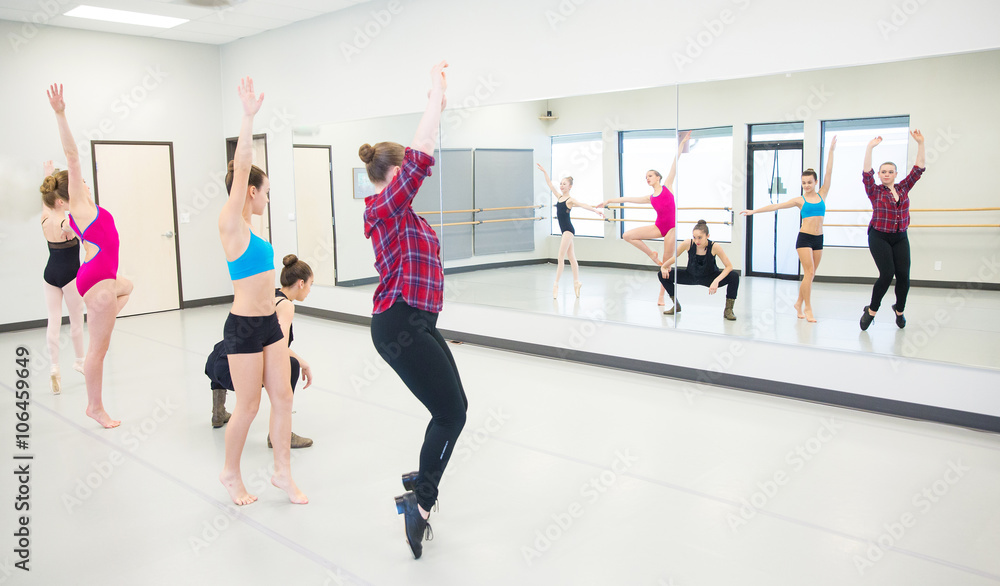 group of young dancers practicing in front of mirror