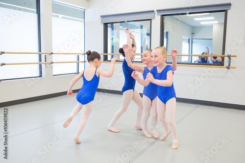 group of young ballet dancers playing in studio