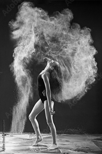 Fototapeta Naklejka Na Ścianę i Meble -  Black and white portrait of young dancer with white powder flipp