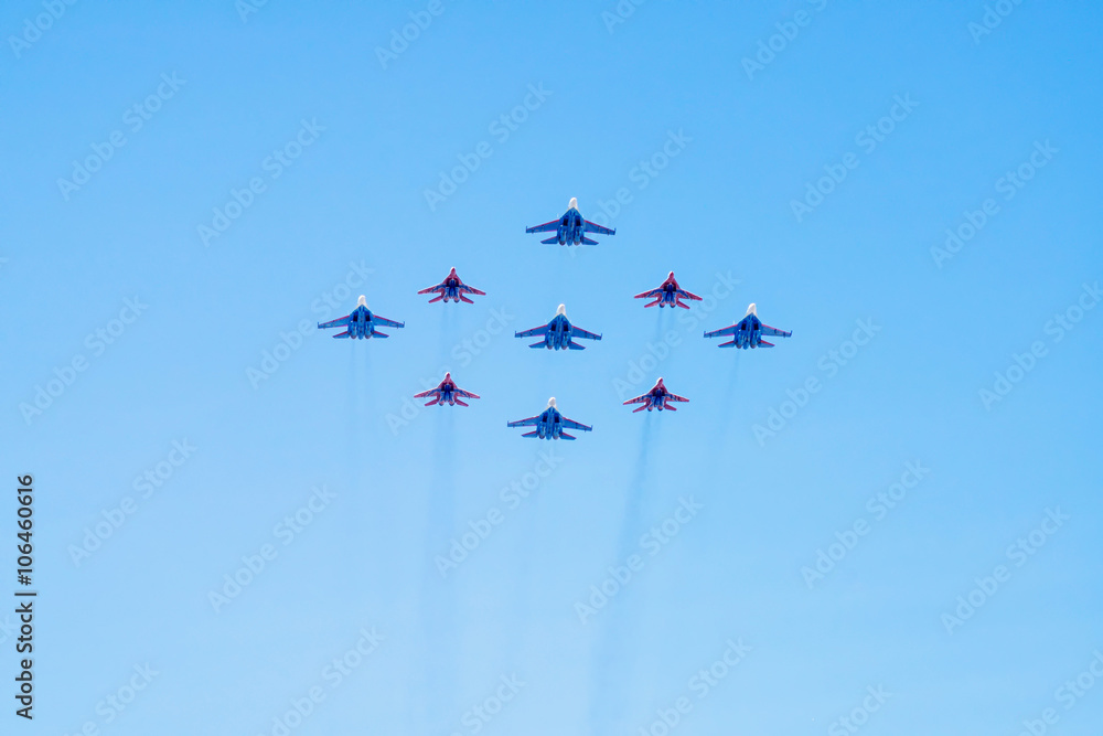 Diamond-shape of 4 Mig-29 The Russian Knights and 5 Su-27 Swifts on blue sky background Diamond-shape of 4 Mig-29 The Russian Knights and 5 Su-27 Swifts on blue sky background