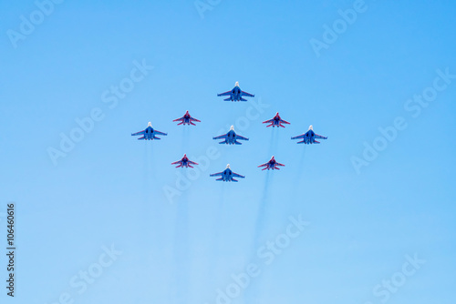 Diamond-shape of 4 Mig-29 The Russian Knights and 5 Su-27 Swifts on blue sky background