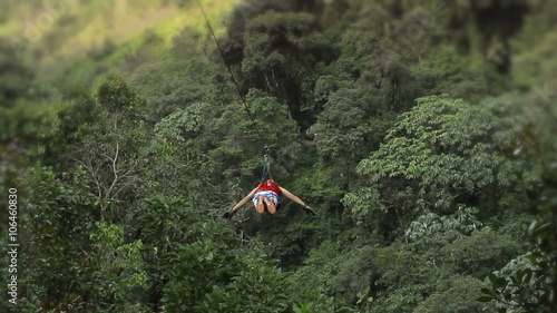 Experience the exhilarating sounds of excitement as the camera captures the thrilling descent on a zipline,with a dramatic tilt downwards.
