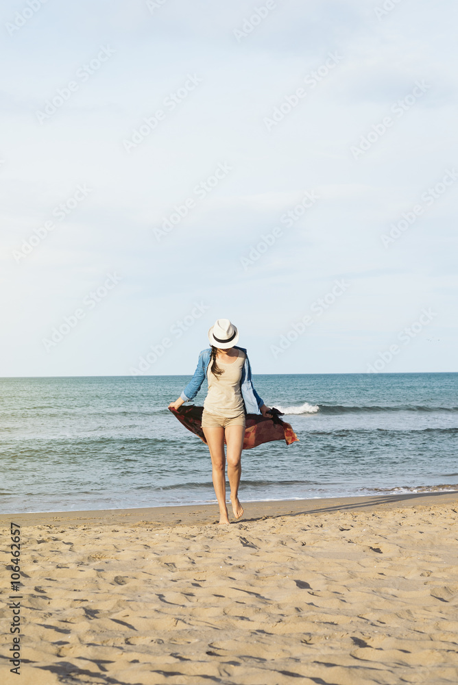 Woman walking away on the idylic beach.