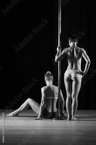 Two women dancing on pylon