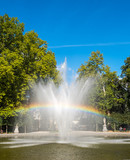 Rainbow from artificial fountain in park