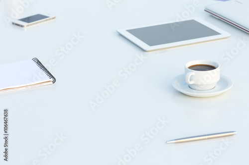 Side View of White Table with Electronics and Stationary photo