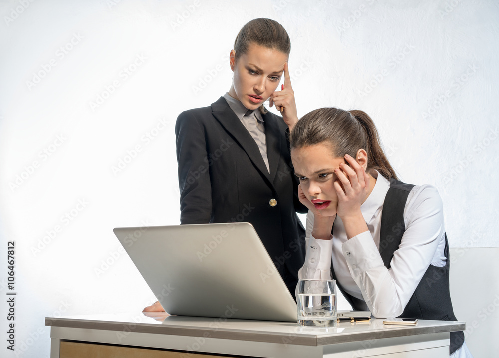 Two businesswomen work at the laptop Two businesswomen work at the laptop