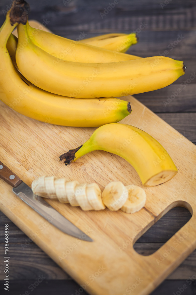 sliced banana with a knife on wooden board sliced banana with a knife on wooden board