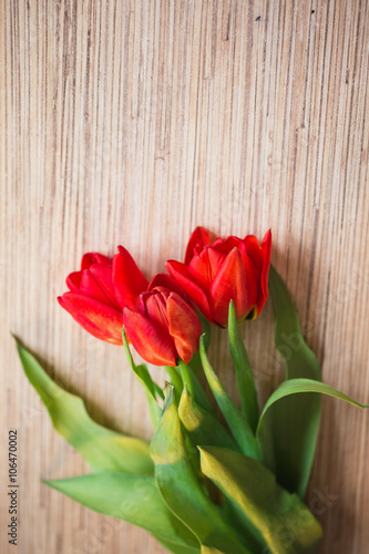 Red tulips on a wooden table