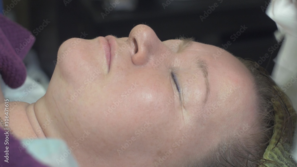 Close up of cosmetologist wipe out face of thick woman in beauty saloon by clearing napkin. Anti aging skincare. Cosmetic procedure. Close up of cosmetologist wipe out face of thick woman in beauty saloon by clearing napkin. Anti aging skincare. Cosmetic procedure.