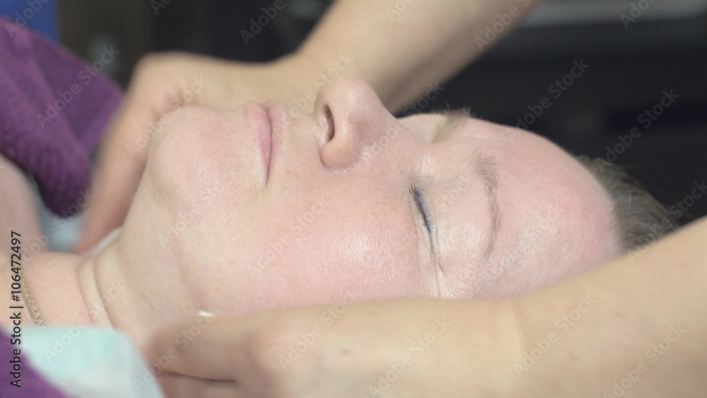 Close up of cosmetologist wipe out face of thick woman in beauty saloon by clearing cotton pad. Anti aging skincare. Close up of cosmetologist wipe out face of thick woman in beauty saloon by clearing cotton pad. Anti aging skincare.