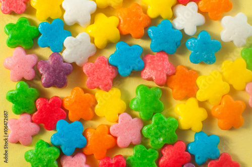 Macro of varicoloured candy on the yellow background