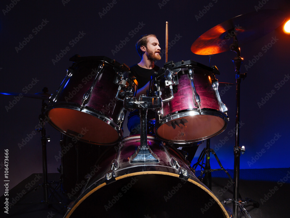 Attractive bearded man drummer sitting and playing on his kit Attractive bearded man drummer sitting and playing on his kit