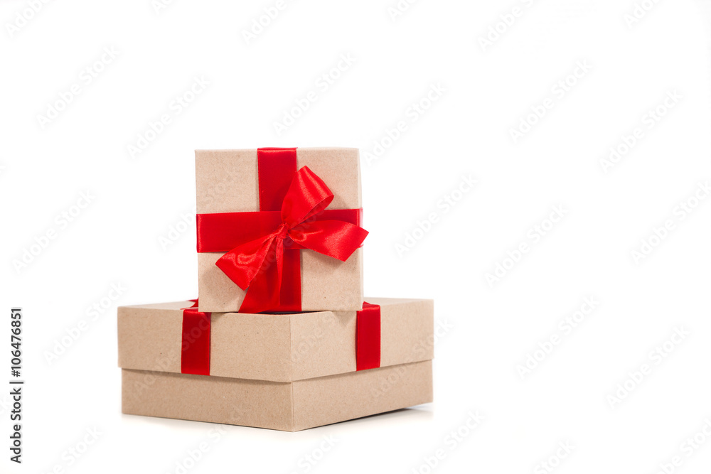 Gift box wrapped in recycled paper with red ribbon 