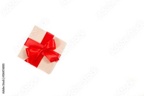 Gift box wrapped in recycled paper with red ribbon 