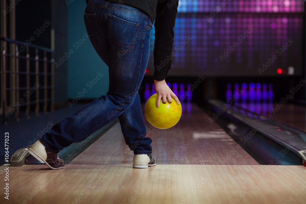 Naklejka premium Male legs and bowling ball in alley.