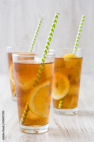 refreshing iced tea with lemon on white wood